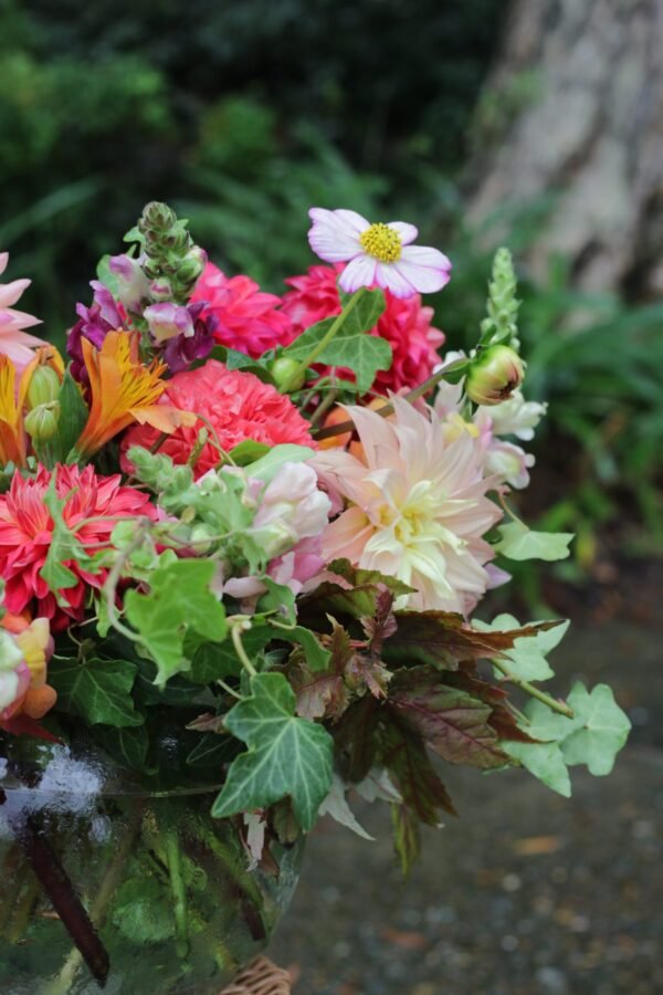 Bright and bold florist’s choice bouquet with seasonal flowers in orange, pink, and yellow tones